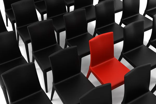 Czerwone krzesło wśród czarnych krzeseł — Zdjęcie stockowe