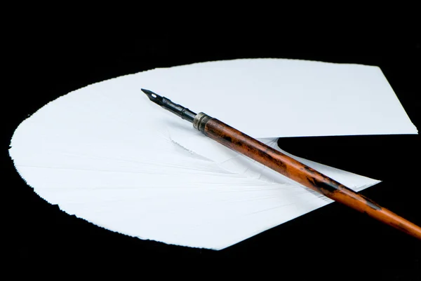 Бумага и старая ручка на черном фоне — стоковое фото
