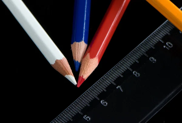 Renkli kalemler ve cetvel üzerindeki siyah arka — Stok fotoğraf