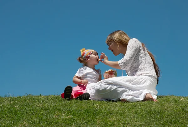 Den unga flickan med barn utomhus — Stockfoto