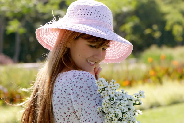 Girl in a hat with a bunch of flowers — Stock Photo, Image