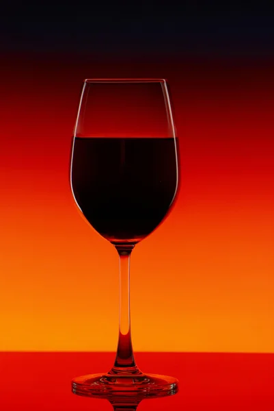 Copo de vinho tinto em um fundo brilhante — Fotografia de Stock