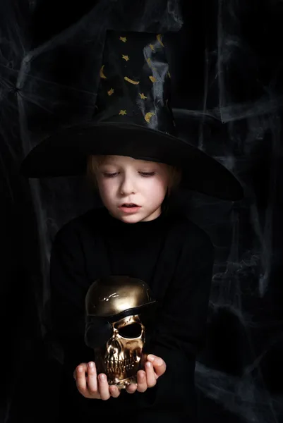 O pequeno mágico com um crânio dourado — Fotografia de Stock