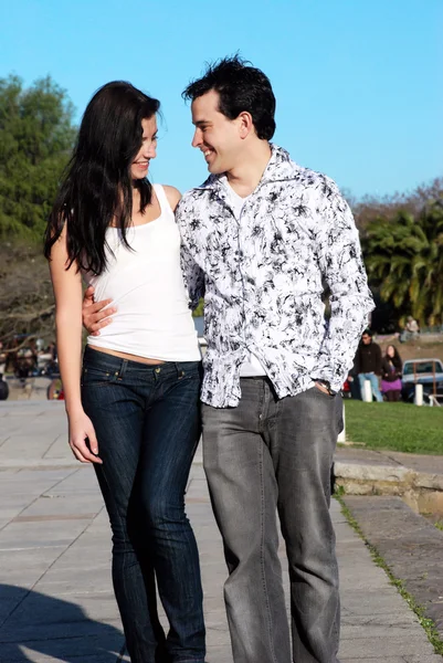 Glückliches junges Paar geht im Park spazieren — Stockfoto