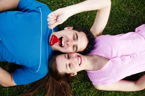 Jonge, een verliefde paar liggen op een gras — Stockfoto