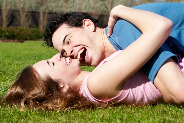 Счастливая молодая пара играет в парке — стоковое фото