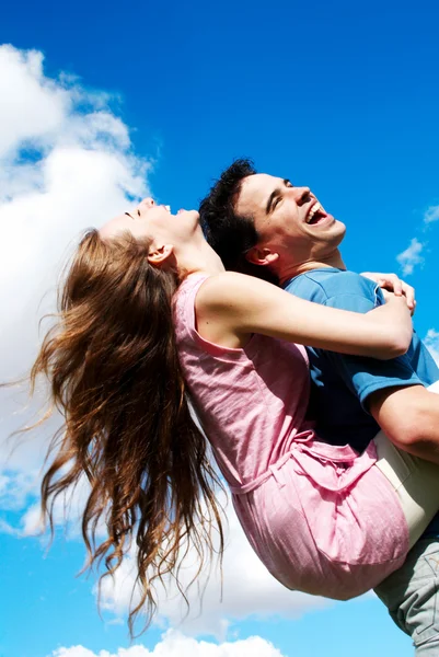 Jovem casal feliz contra o céu — Fotografia de Stock