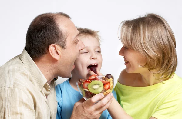 Счастливая семья с фруктовым салатом — стоковое фото