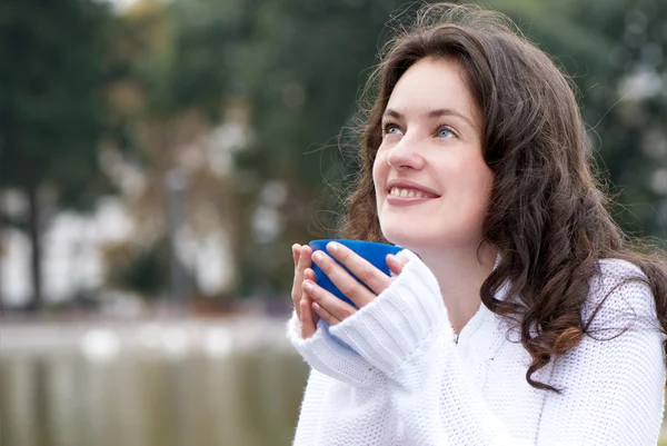 Genç kadın bir fincan sıcak bir içecek — Stok fotoğraf