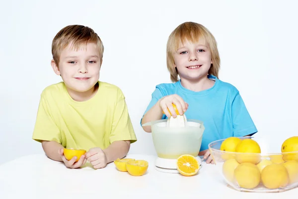 Kinder pressen Orangensaft aus — Stockfoto