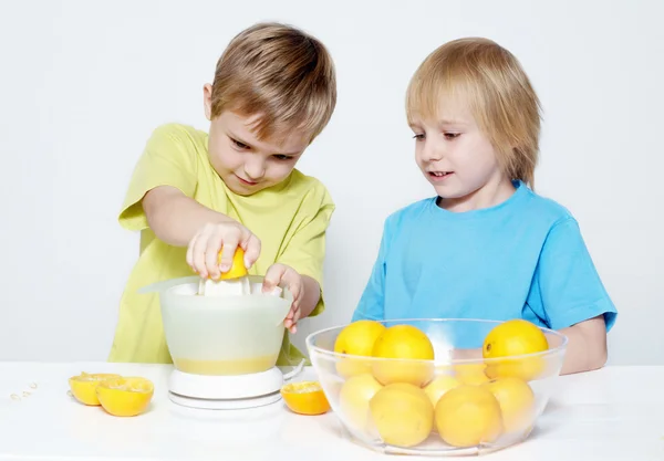 Los niños exprimen el jugo de naranja — Foto de Stock