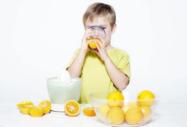 Der Junge trinkt Orangensaft — Stockfoto