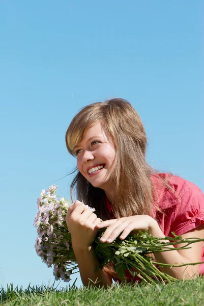 Meisje met trossen van bloemen — Stockfoto