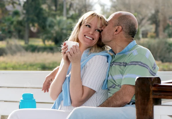 Happy couple on a bench in park — Stock Photo, Image