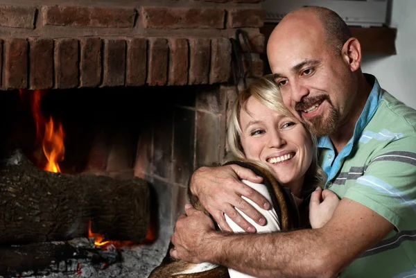 Couple near a fireplace — Stock Photo, Image