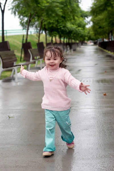 Girl running on wet avenue after a rain — Stock Photo, Image