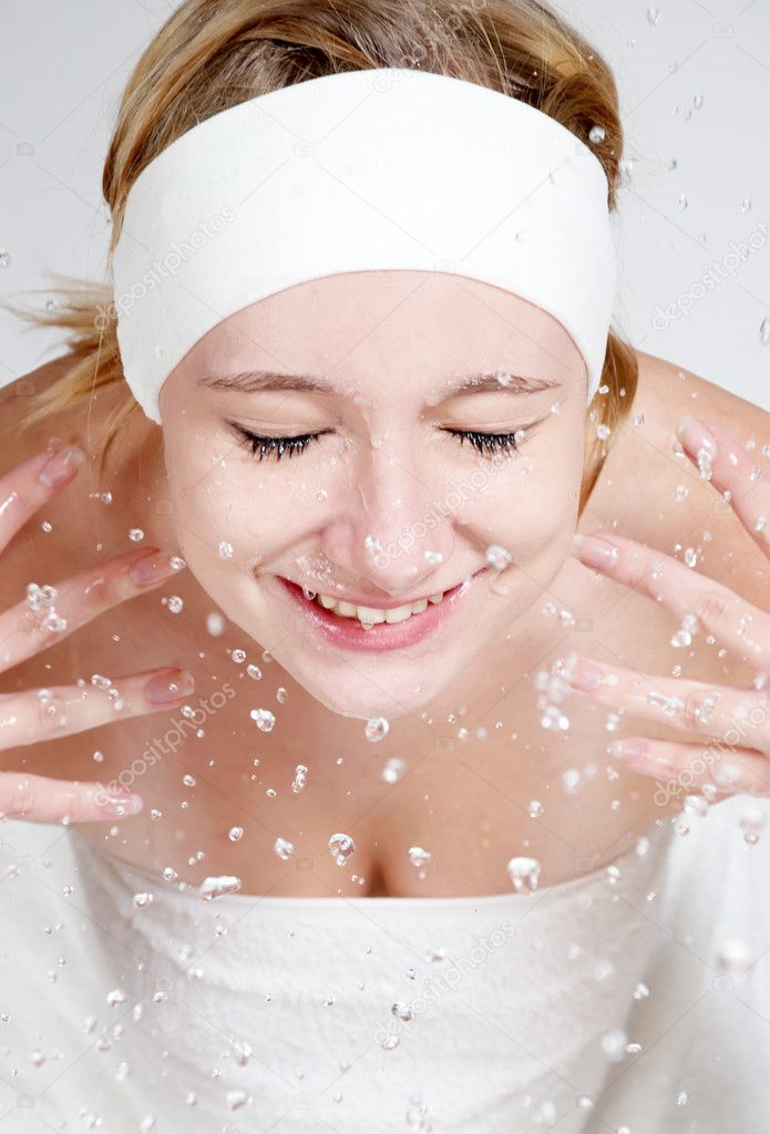 Happy young girl wash her face