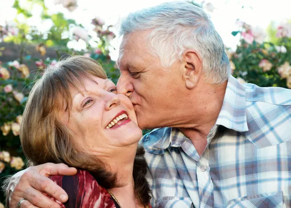 Kissing happy elderly couple in love outdoor — Stock Photo, Image