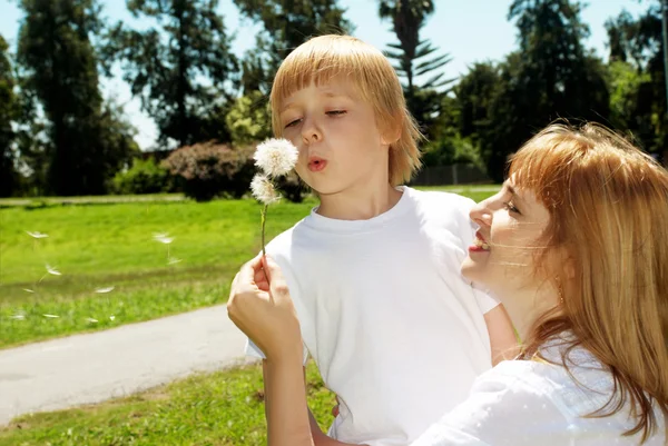 Mother with the son with dandelions — Stock Photo, Image