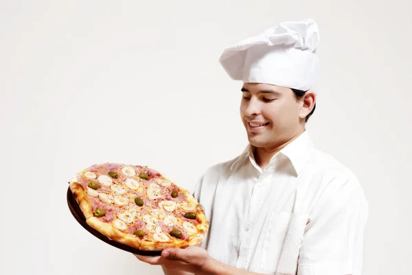 Glücklich attraktive Köchin mit einer Pizza — Stockfoto