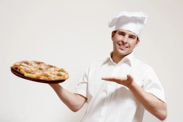 Cozinheiro atraente feliz com uma pizza — Fotografia de Stock