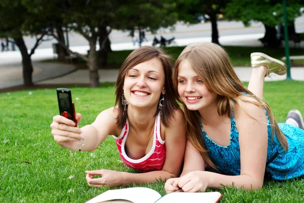 Deux copines dans le parc avec un téléphone portable — Photo