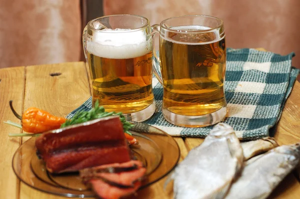 Пиво и рыба на столе — стоковое фото