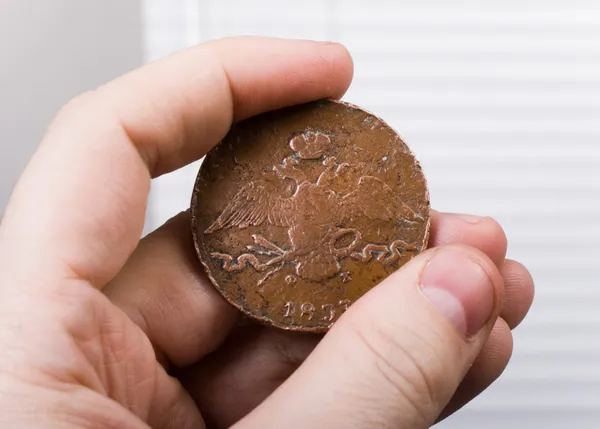Moneda vieja en la mano — Foto de Stock