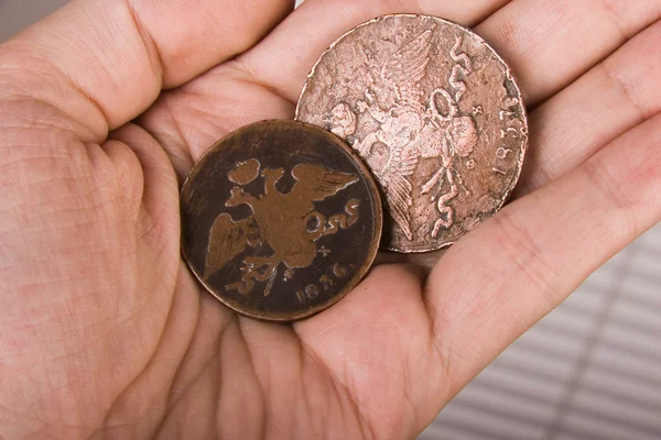 Monedas antiguas en mano — Foto de Stock