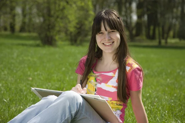 Beautiful girl painting in park — Stock Photo, Image