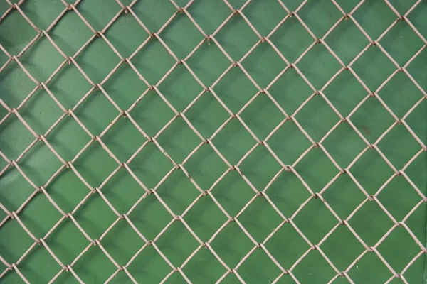 Malla metálica sobre fondo verde — Foto de Stock