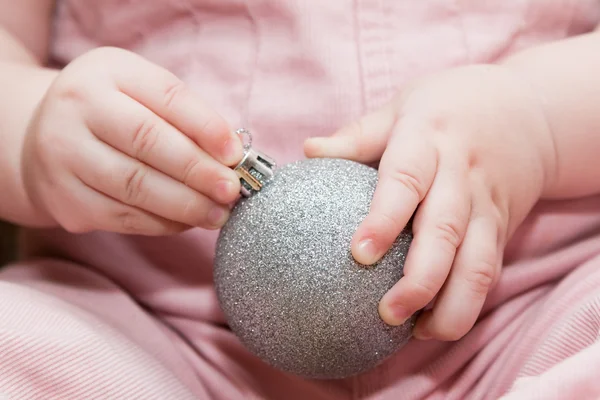 Ребенок держит серебряный рождественский бал — стоковое фото