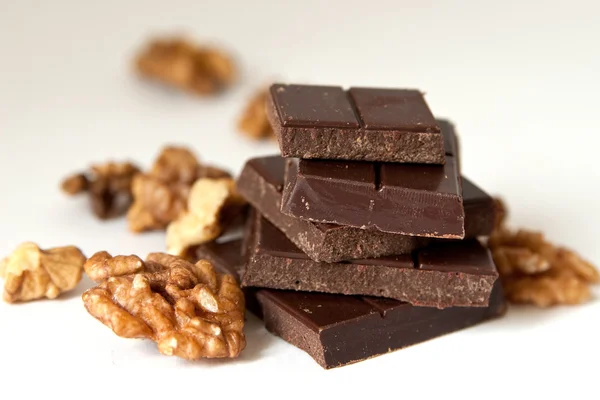 Bloques de chocolate y nueces en blanco — Foto de Stock
