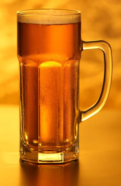 Kubek piwa z bańki na żółty — Zdjęcie stockowe
