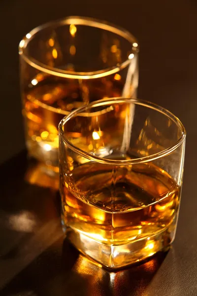 Glas whiskey och is på bardisken i brun Stockbild