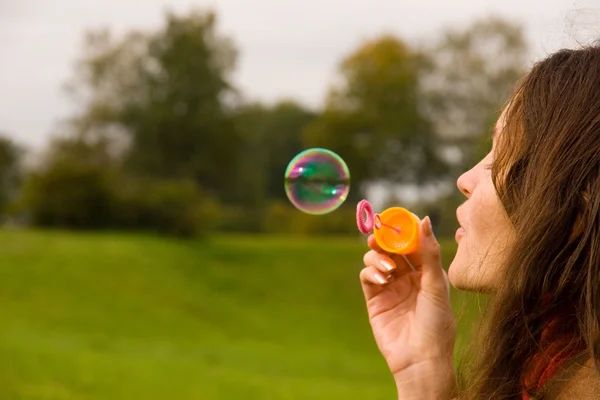 Aranyos lány fúj buborékok — Stock Fotó