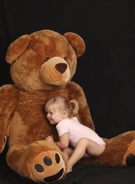Beautiful young girl with huge bear — Stock Photo, Image