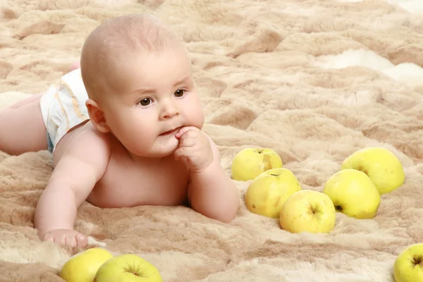 Thoughtful little baby boy in apples — Stock Photo, Image