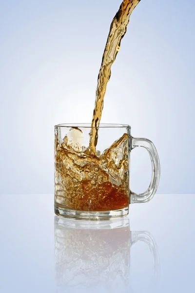 Pouring tea to a transparent teacup — Stock Photo, Image