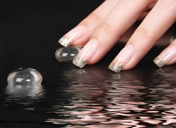Golden nails in water — Stock Photo, Image