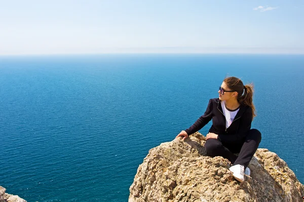 Женщина на скале и море — стоковое фото