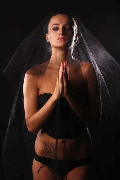 Femme priante en lingerie noire — Photo