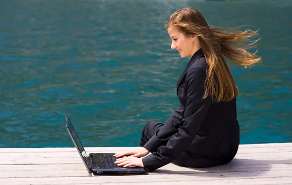 Женщина с ноутбуком и морем — стоковое фото