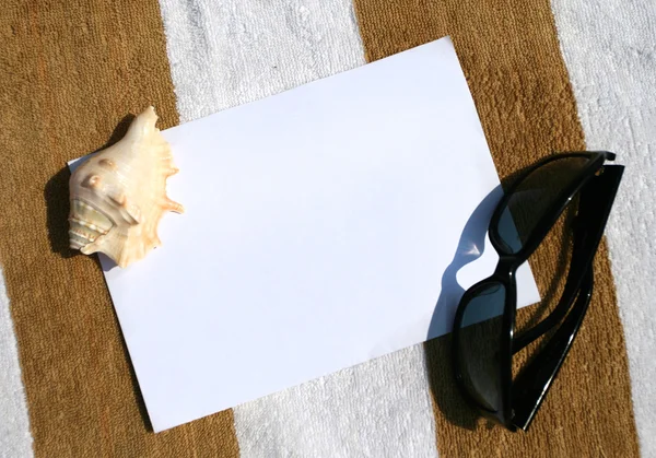 Deniz kabuğu ve kağıt üzerinde güneş gözlüğü — Stok fotoğraf