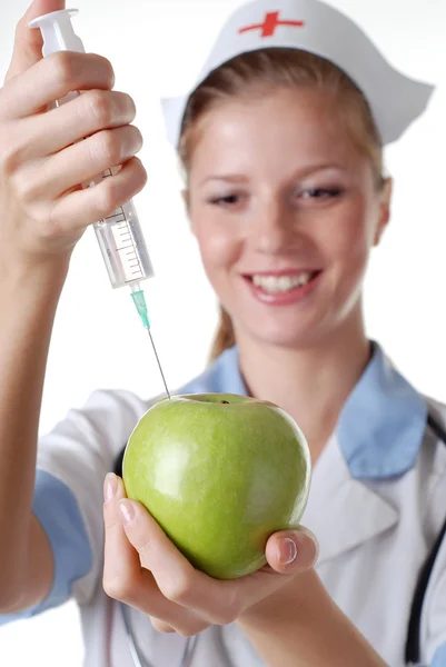 Медсестра со шприцем и яблоком — стоковое фото