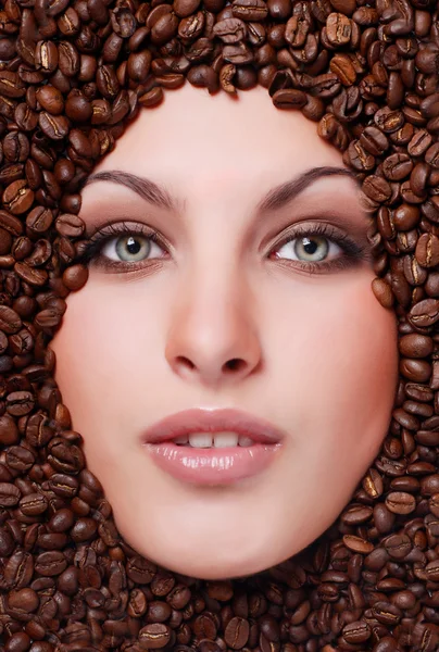 Женское лицо с кофейными зёрнами — стоковое фото