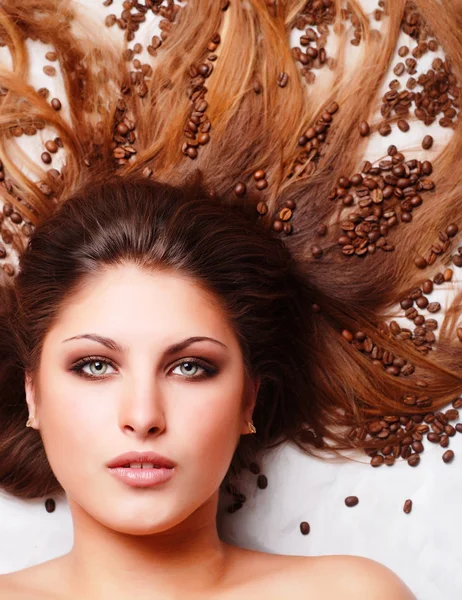 Kvinnans ansikte med kaffebönor — Stockfoto