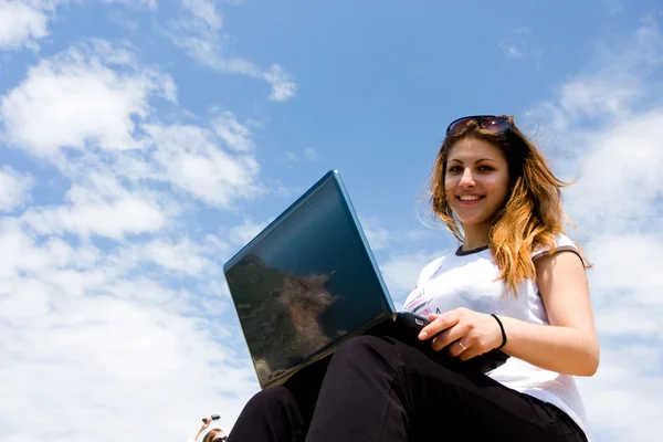 Žena s notebookem a modrá obloha — Stock fotografie