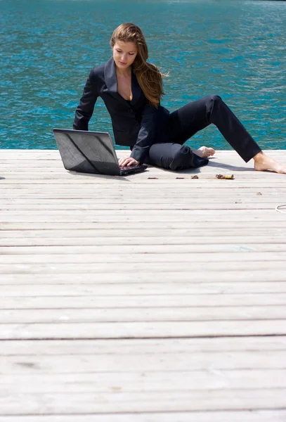 Kadın dizüstü bilgisayar ve deniz — Stok fotoğraf