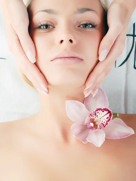 Rosto de bela jovem com orquídea delicada — Fotografia de Stock